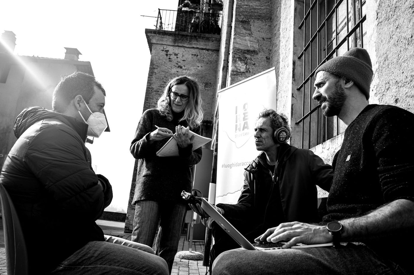 Un’intervista all’aperto per Morena Stories: microfono, cuffie, appunti e un portatile, davanti al banner del progetto