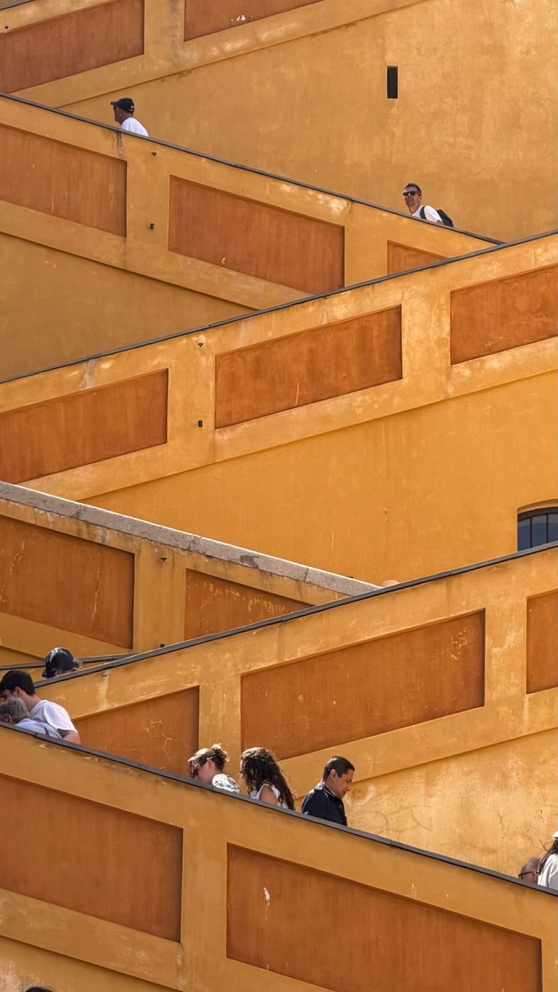 Rampe di scale ocra a zig-zag, con persone che salgono e scendono